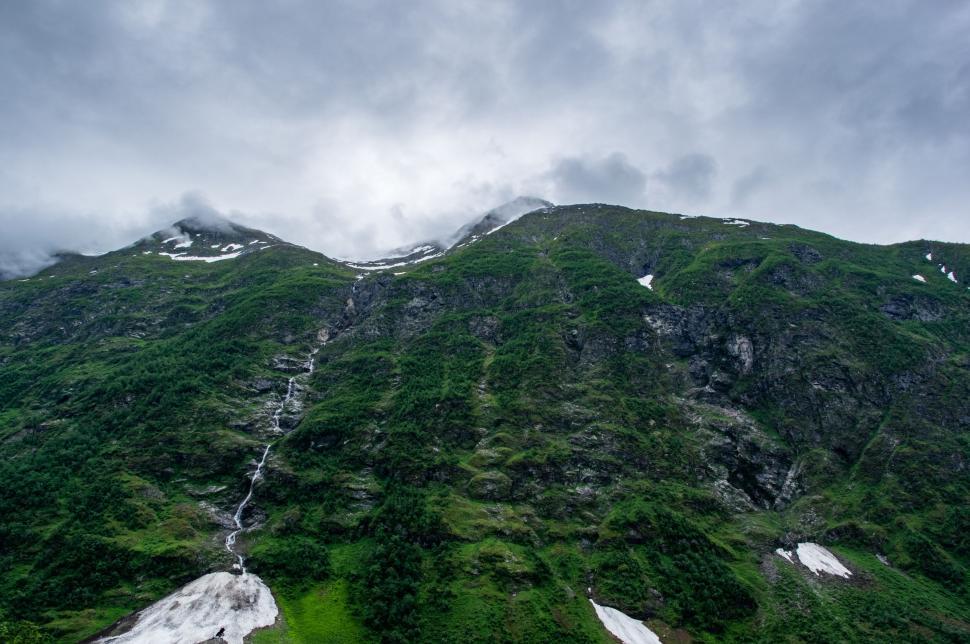 Free Image of Towering Mountain Covered in Snow and Green Grass 