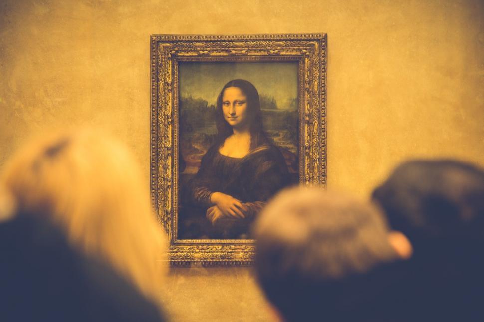Free Image of Woman Examining Painting of Womans Face 