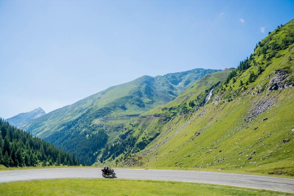 Free Image of Car Driving Down a Winding Mountain Road 