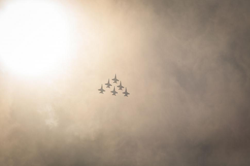 Free Image of Group of Fighter Jets Flying Through Cloudy Sky 