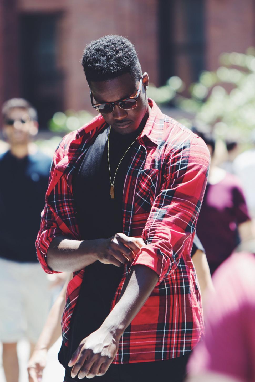 Free Image of Man in Red and Black Checkered Shirt Looking at Cell Phone 