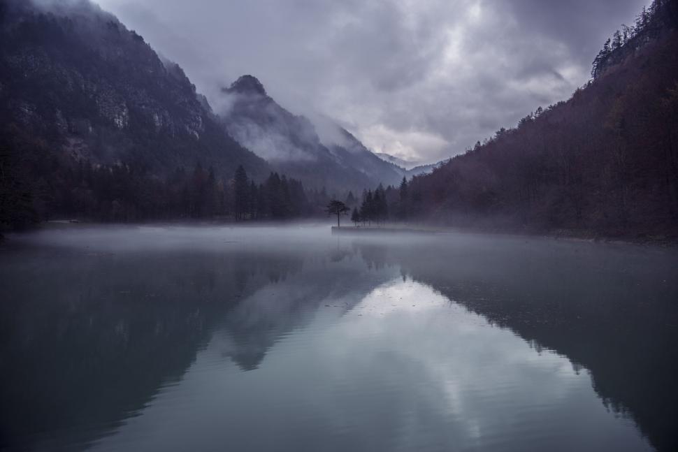 Free Image of A Lake Surrounded by Mountains Under a Cloudy Sky 