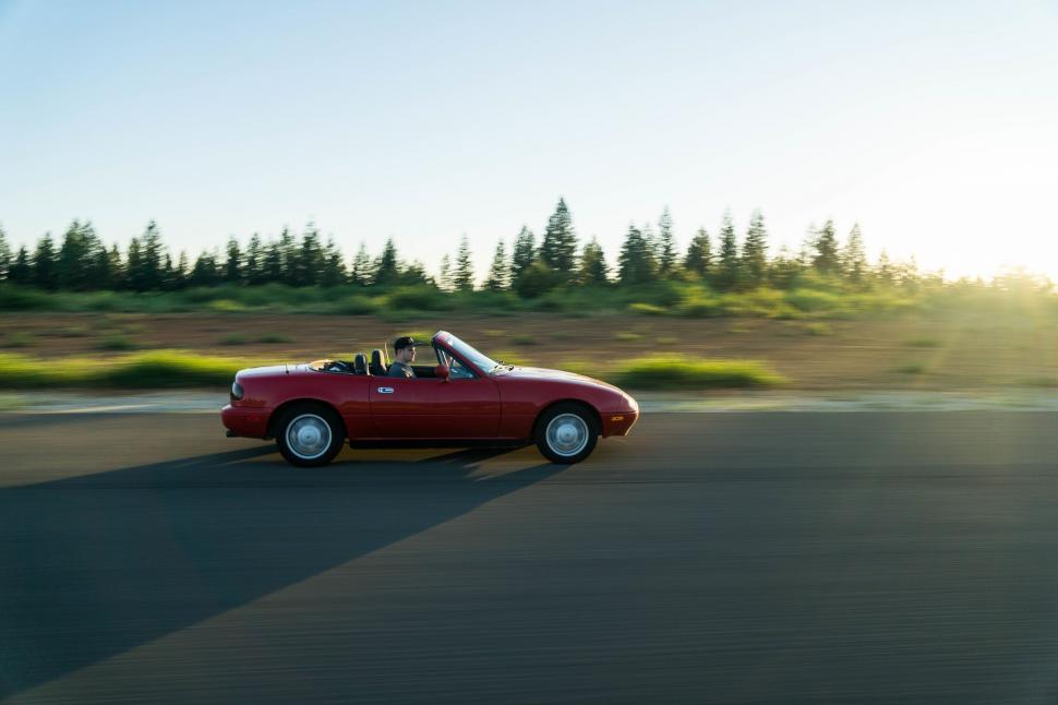 Free Image of Red Convertible Car Driving Down a Road 
