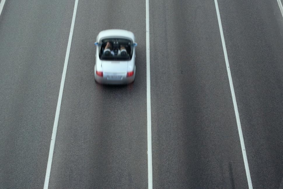 Free Image of Car Driving Down Road With Roof Down 