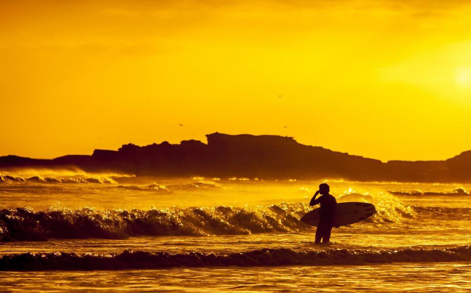 Free Image of Man Holding Surfboard Standing in Ocean 