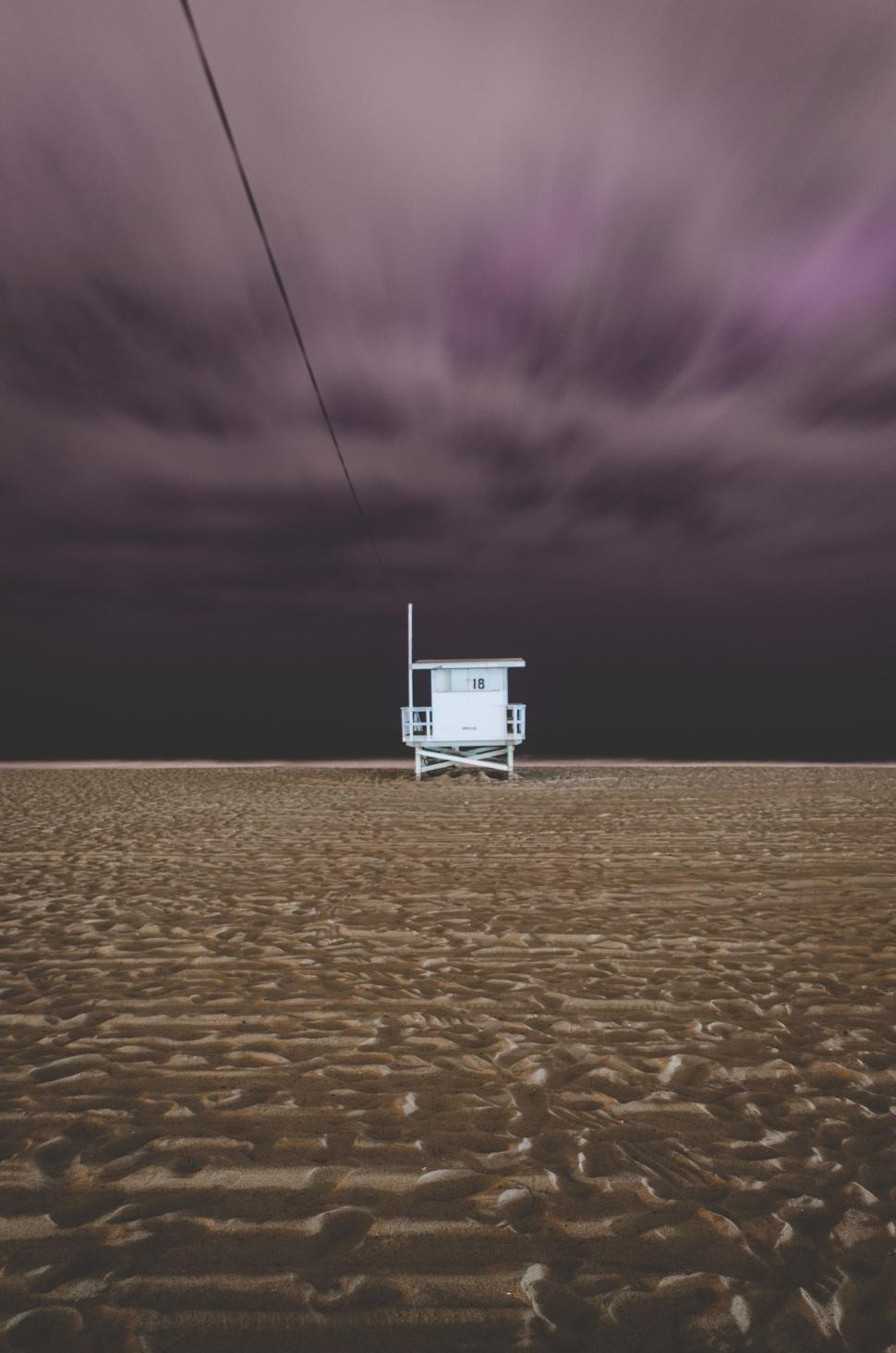 Free Image of Lifeguard Chair on Beach Under Cloudy Sky 