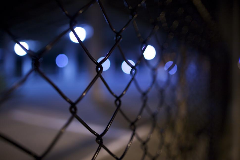 Free Image of Blurry Night Shot of Chain Link Fence 