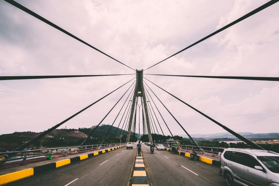 Free Image of Car Driving Across Bridge on Cloudy Day 