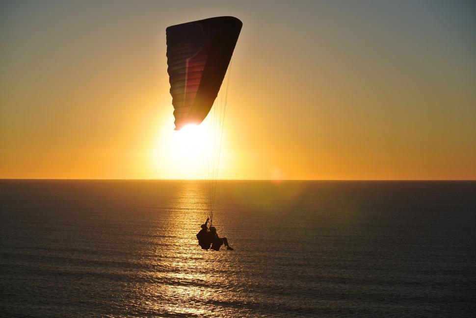 Free Image of Parasailer Flying Over Ocean at Sunset 