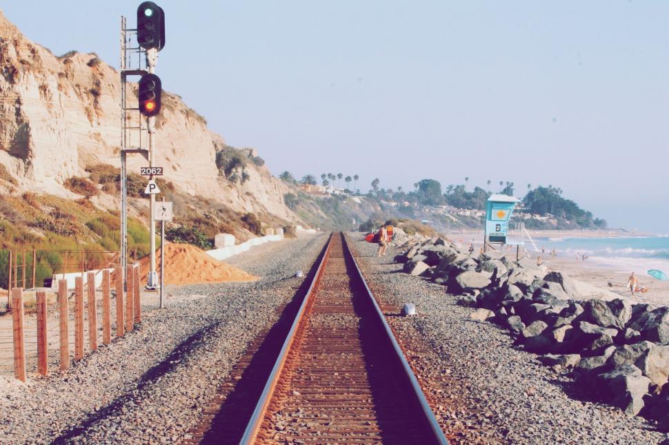 Free Image of Train Track Alongside Beach and Cliff 