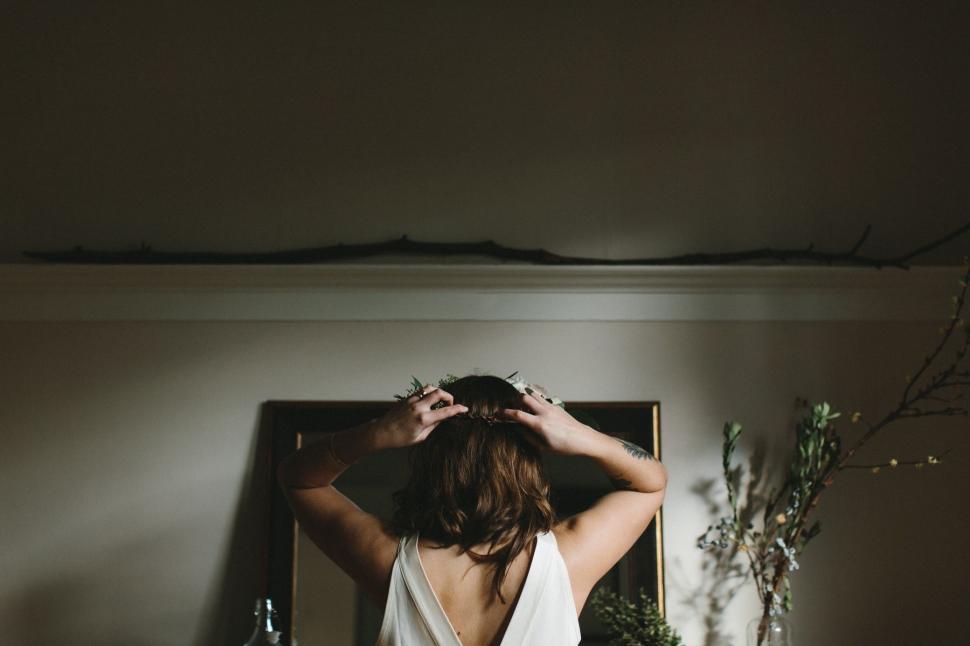 Free Image of Woman in White Dress Standing in Front of Mirror 