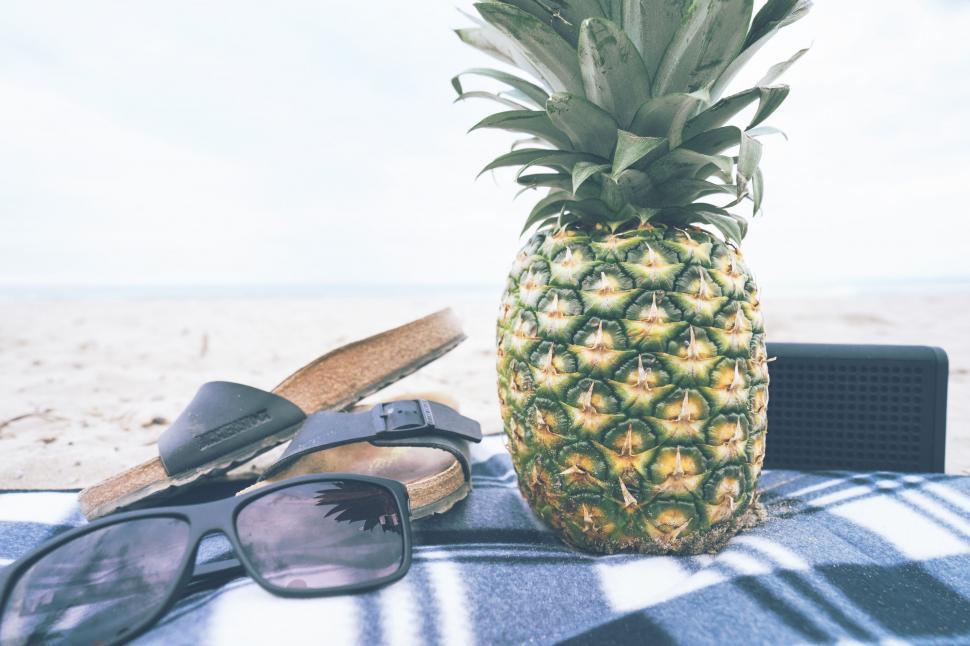 Free Image of Pineapple and Sunglasses on Blanket by the Beach. 