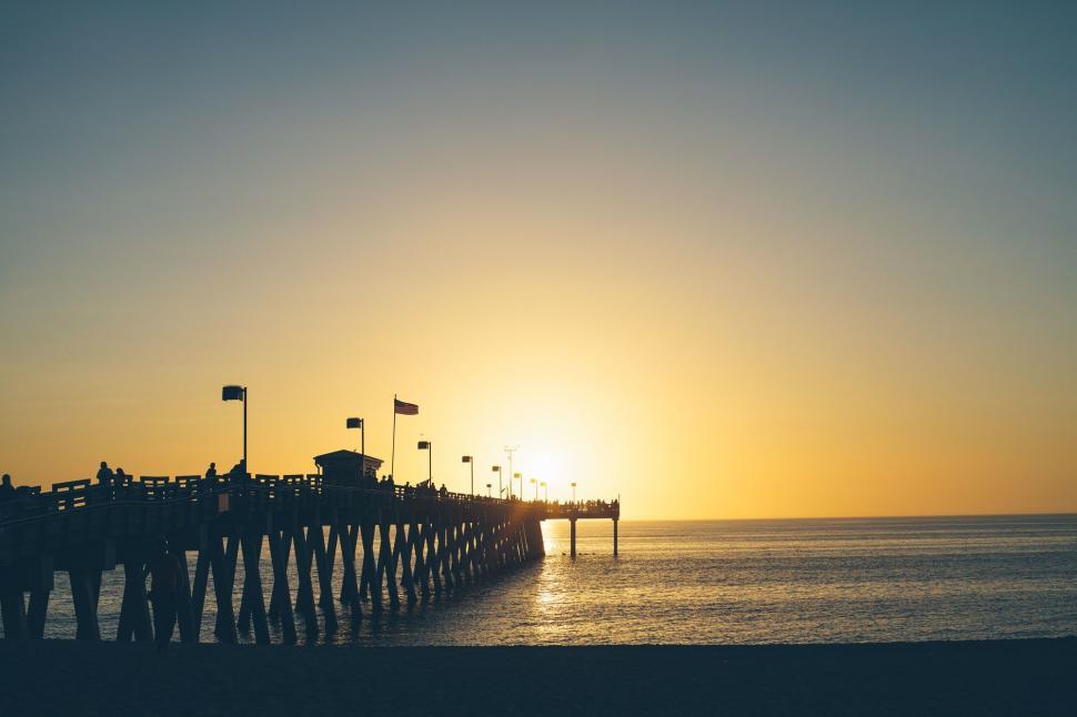 Free Image of Sun Setting Over Ocean and Pier 