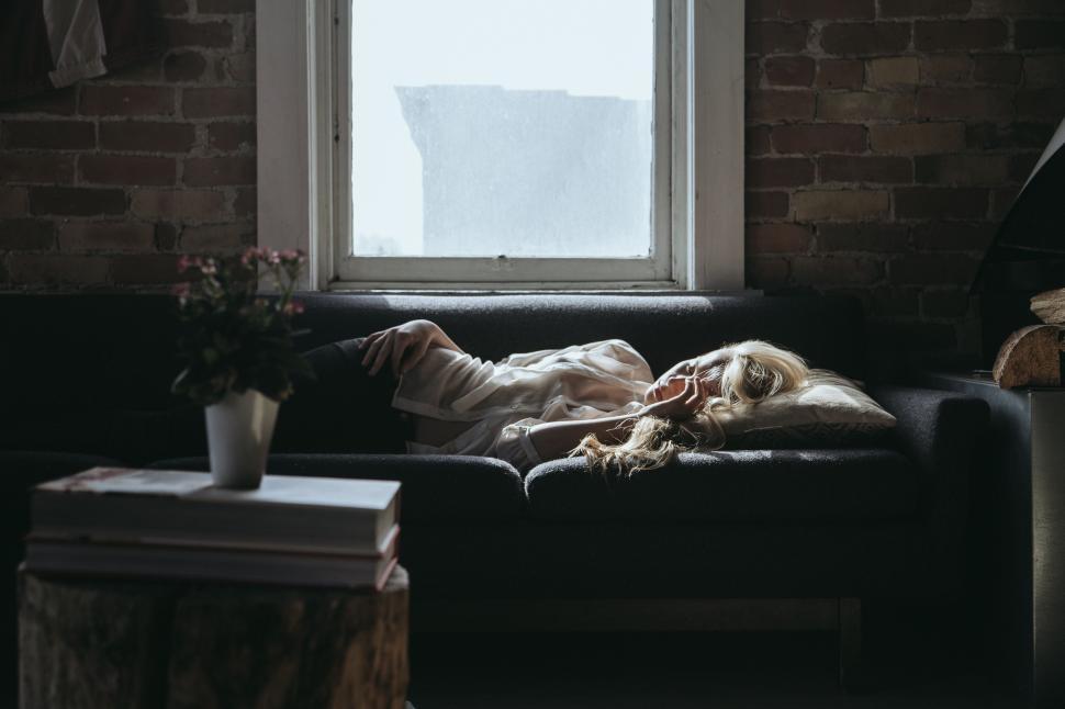 Free Image of Person Laying on Couch by Window 