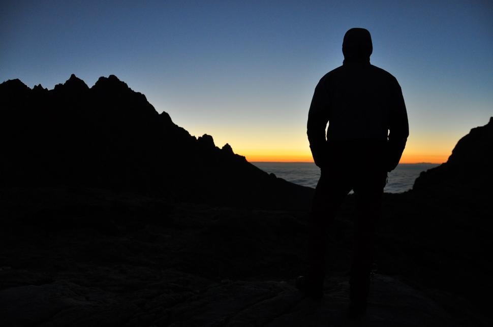 Free Image of Man Standing on Mountain Overlooking Ocean 
