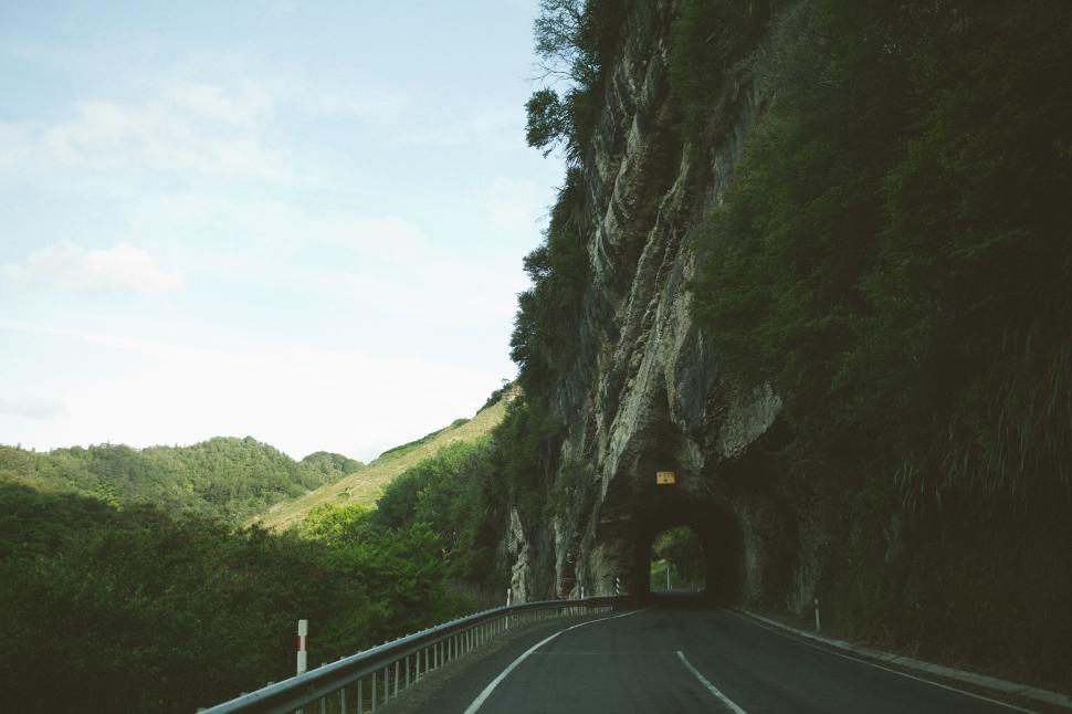 Free Image of Car Driving Down Road Alongside Mountain 