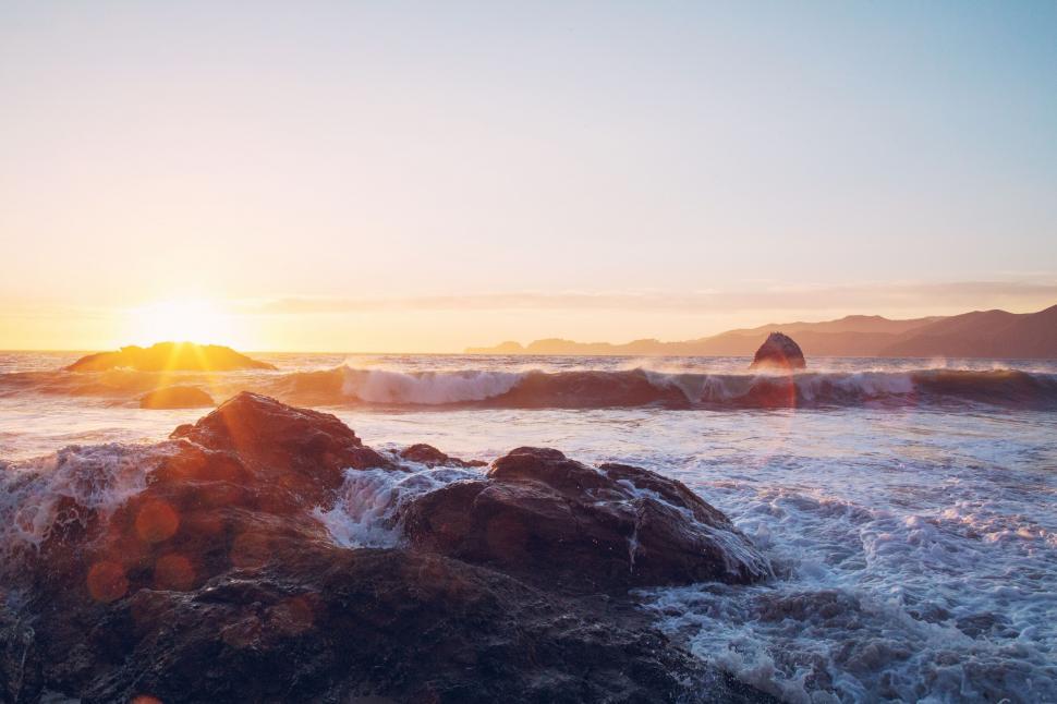 Free Image of Sun Setting Over Ocean Waves 