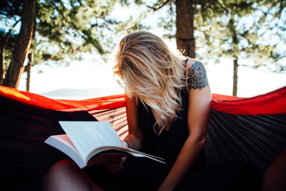 Free Image of Woman Relaxing in Hammock While Reading Book 