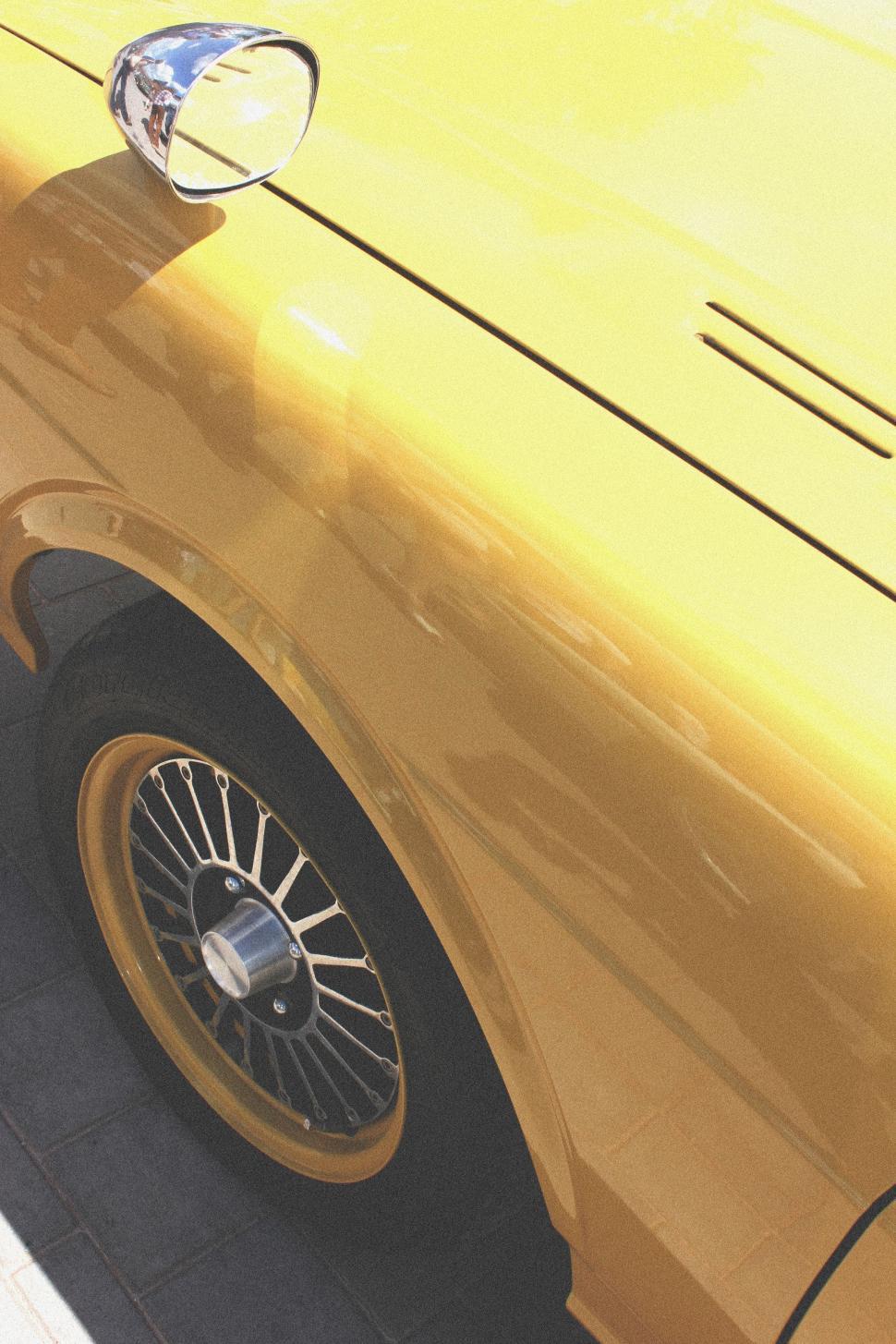 Free Image of Close-Up of Yellow Car Parked on Roadside 