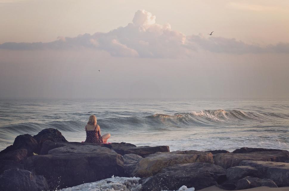 Free Image of Person Sitting on Rock Near Ocean 