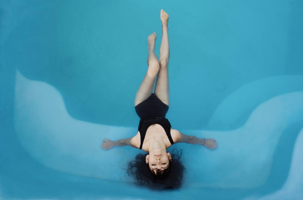 Free Image of Woman in Black Swimsuit Floating in Pool 