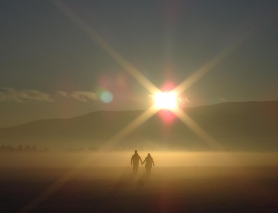 Free Image of Couple Walking Across Foggy Field 