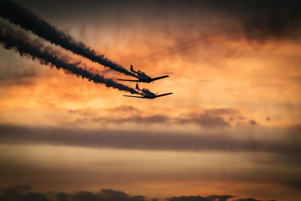 Free Image of Two Planes Flying Through a Cloudy Sky 