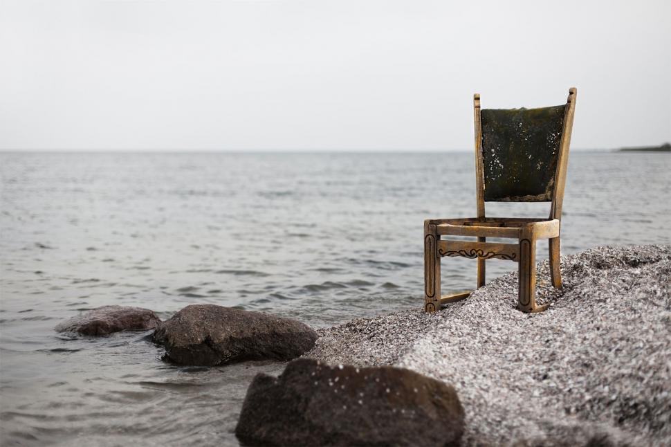 Free Image of Chair on Rocky Beach by the Ocean 