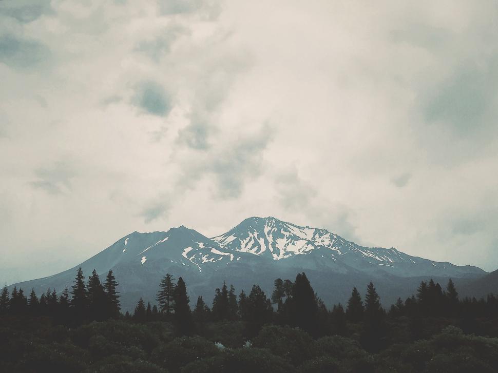 Free Image of Mountain Covered in Clouds and Trees Under Cloudy Sky 