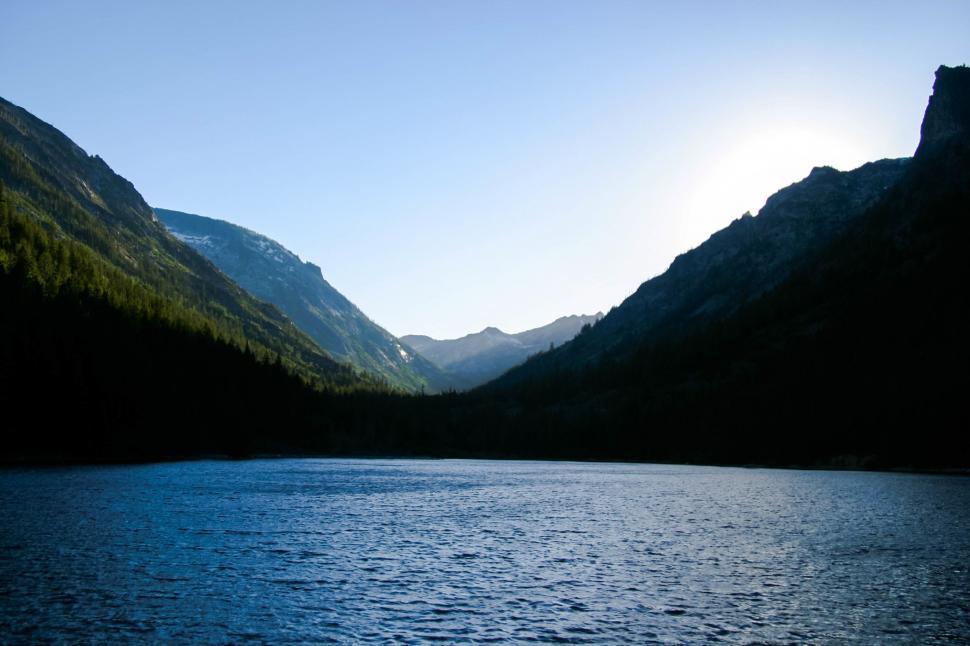 Free Image of Majestic Mountains and Trees Surrounding a Pristine Body of Water 