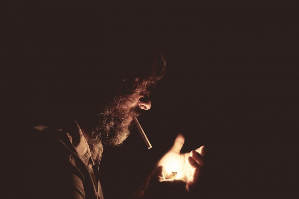 Free Image of Man Holding Lit Candle in the Dark 