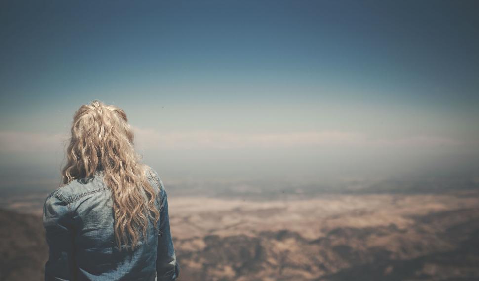 Free Image of Woman Standing on Mountaintop, Looking at Sky 