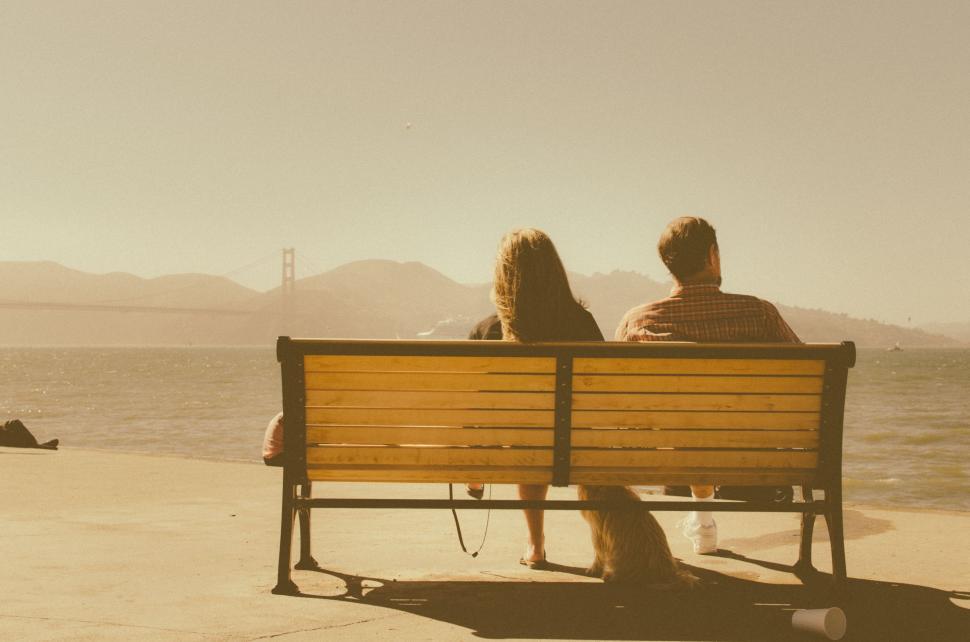 Free Image of Two People Sitting on a Bench by the Water 