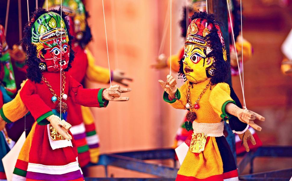 Free Image of Colorful Dolls Hanging From Strings 