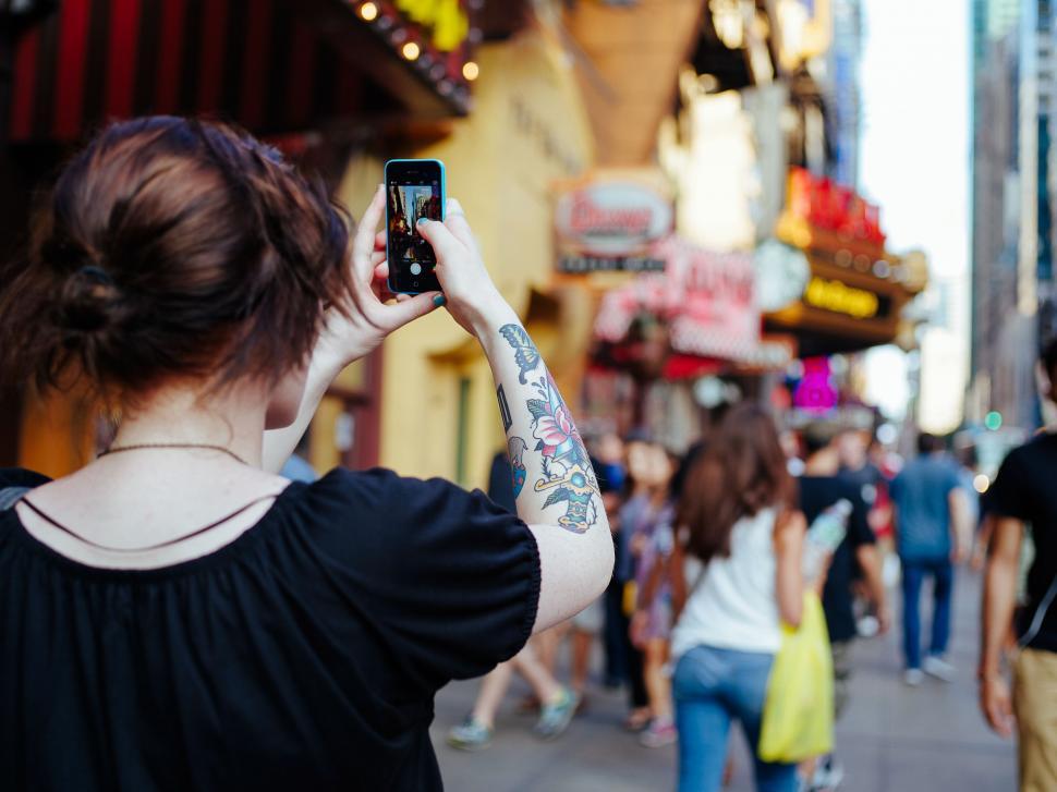 Free Image of Woman Taking Picture of Crowd of People 