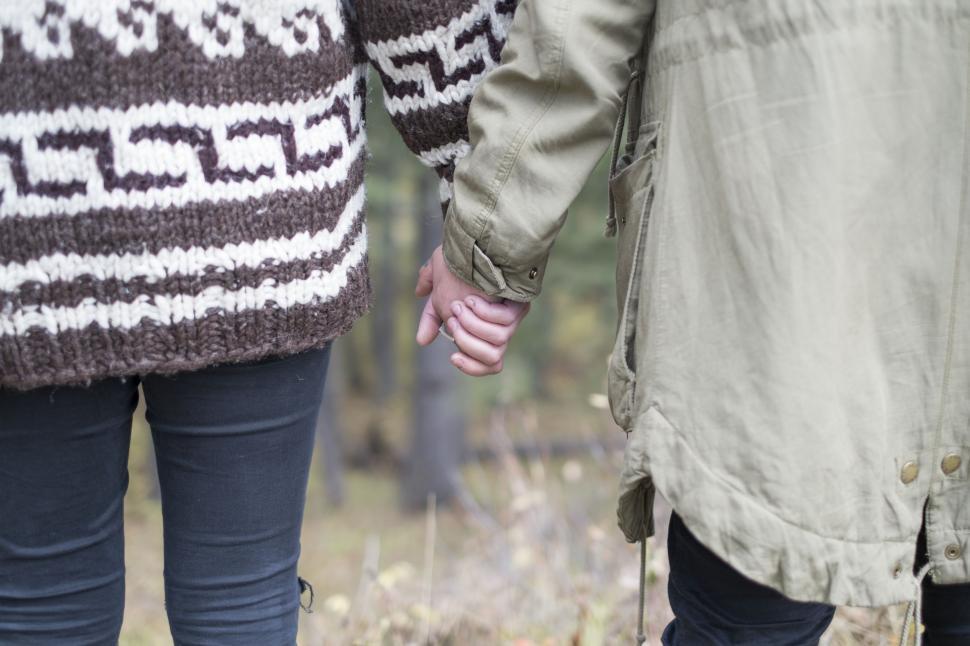 Free Image of Pair Holding Hands While Walking in the Forest 