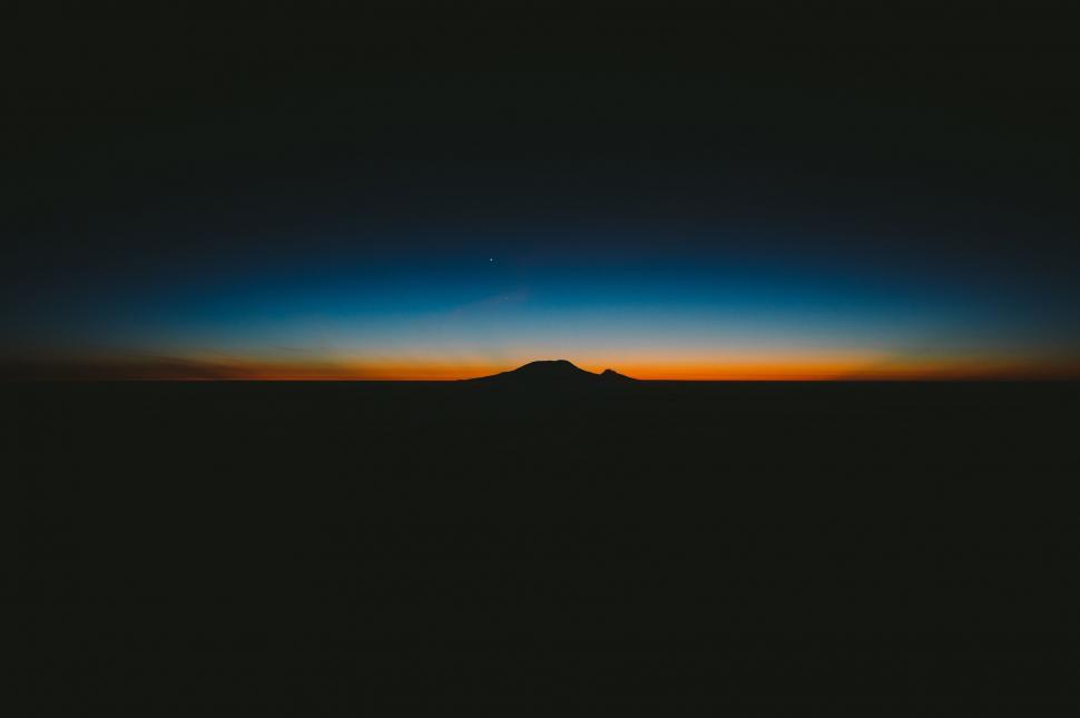 Free Image of Sun Setting Over Mountain in Distance 