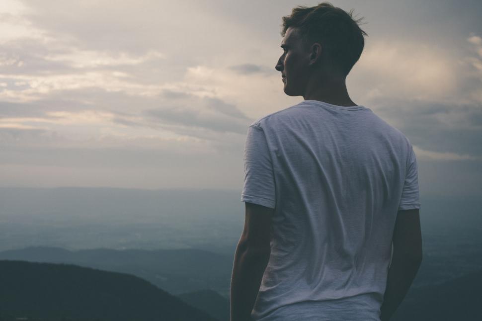Free Image of Man Standing on Top of Mountain Looking at Sky 