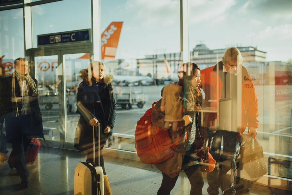 Free Image of Group of People Standing With Luggage 