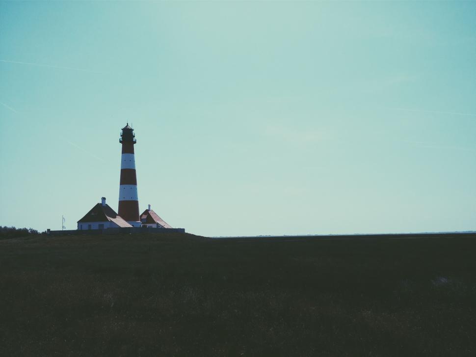 Free Image of Lighthouse Overlooking Hill Under Blue Sky 