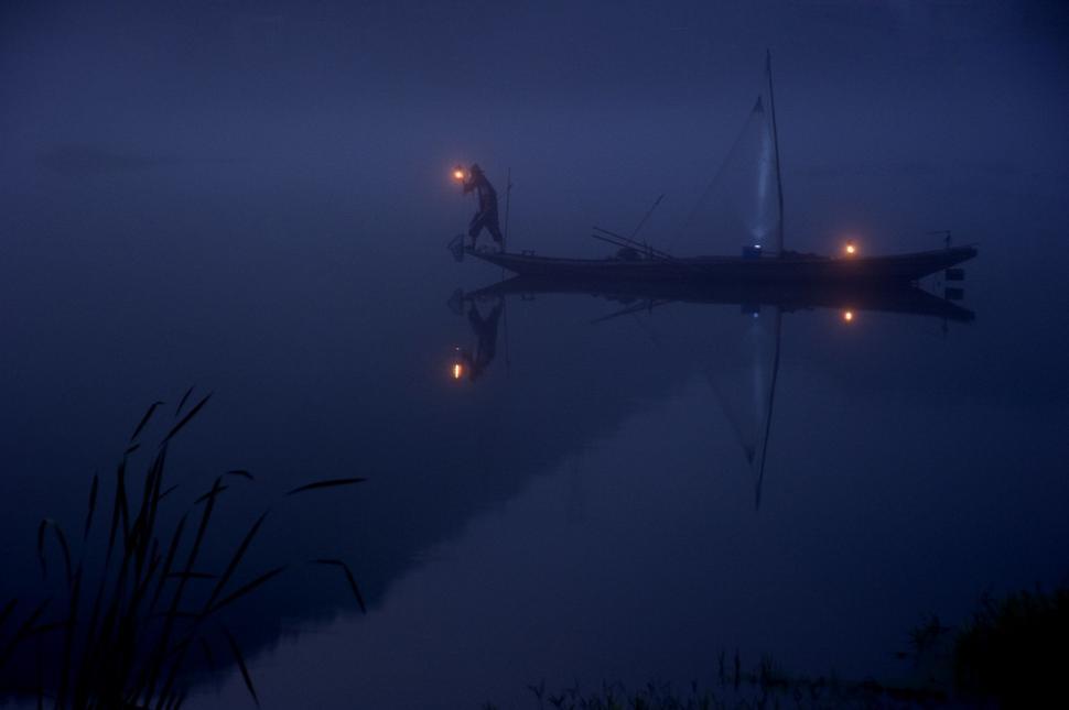 Free Image of Boat Floating on Top of Lake at Night 