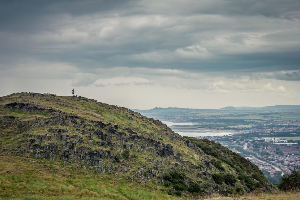 Free Image of Man Standing on Top of Lush Green Hillside 