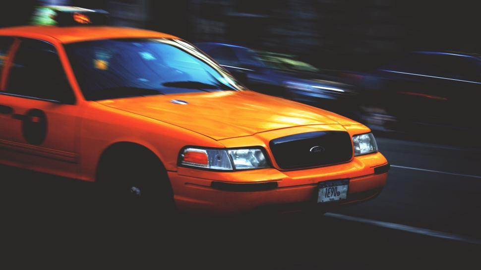 Free Image of Yellow Taxi Cab Driving Down a Street 