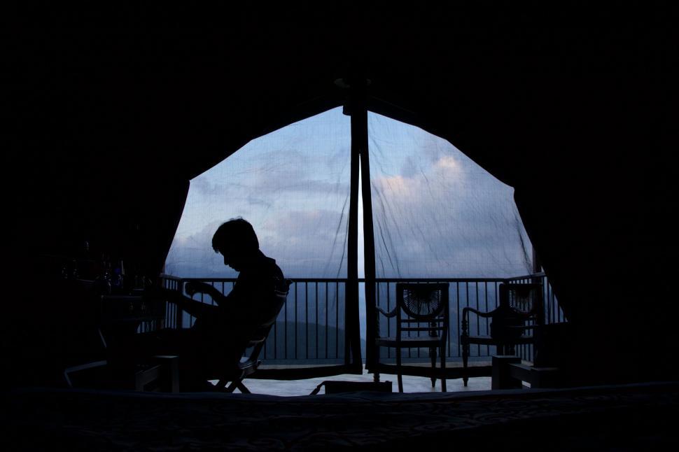 Free Image of Person Sitting in Front of Window Silhouette 