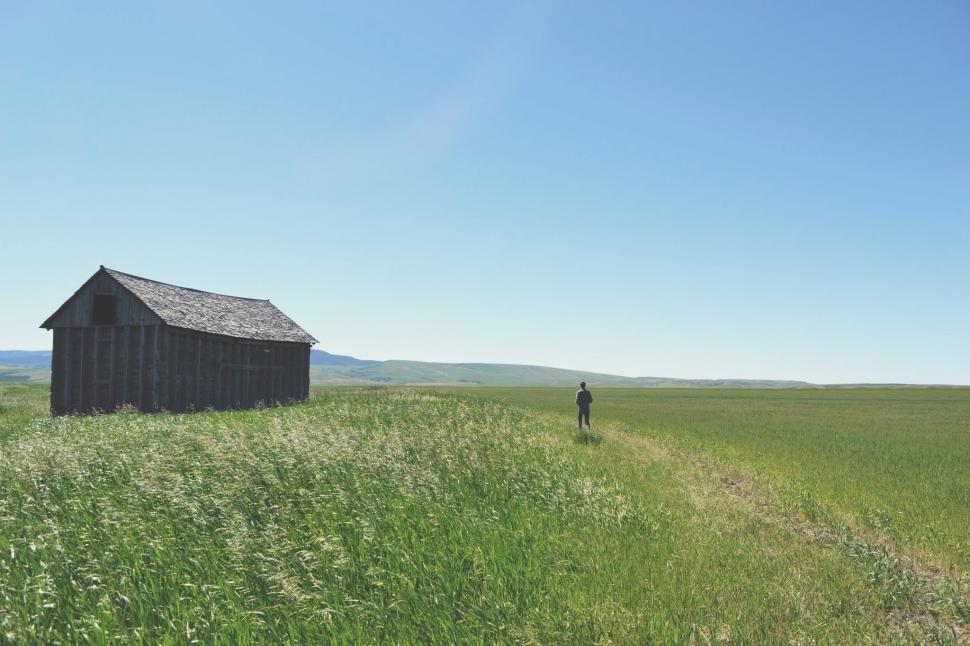Free Image of Man Standing in Field Next to Barn 