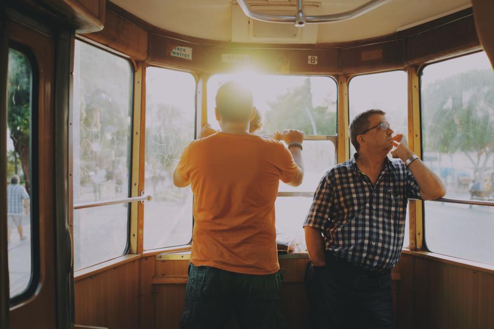 Free Image of Men Standing Together Near a Window 