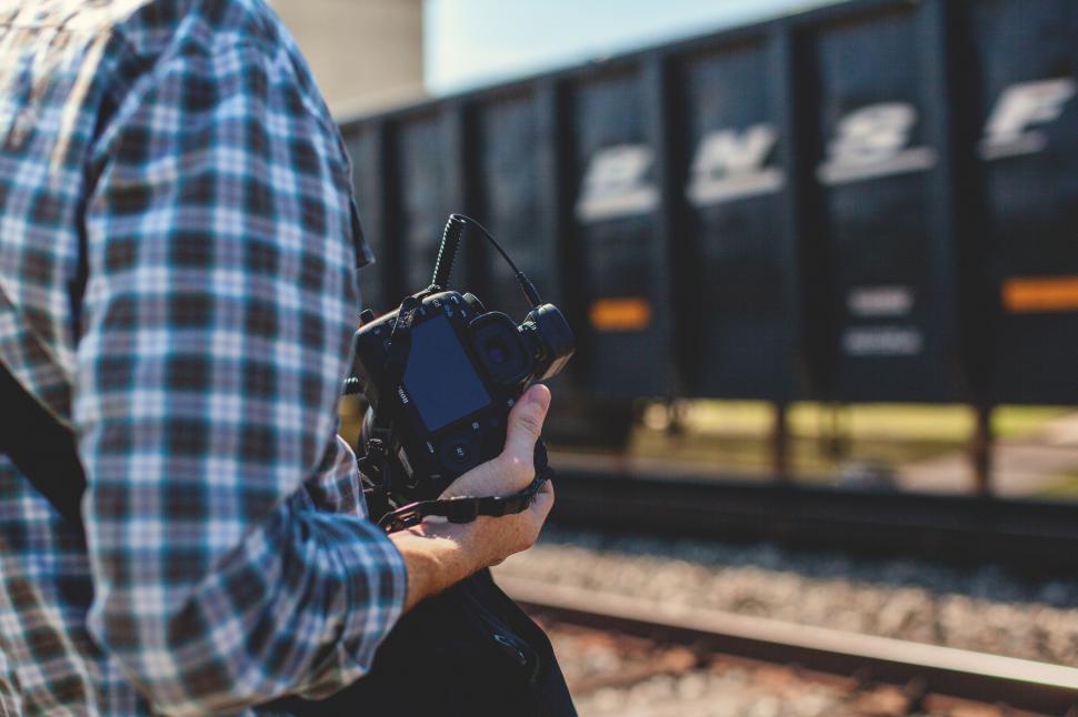 Free Image of Man Holding Camera Near Train Track 