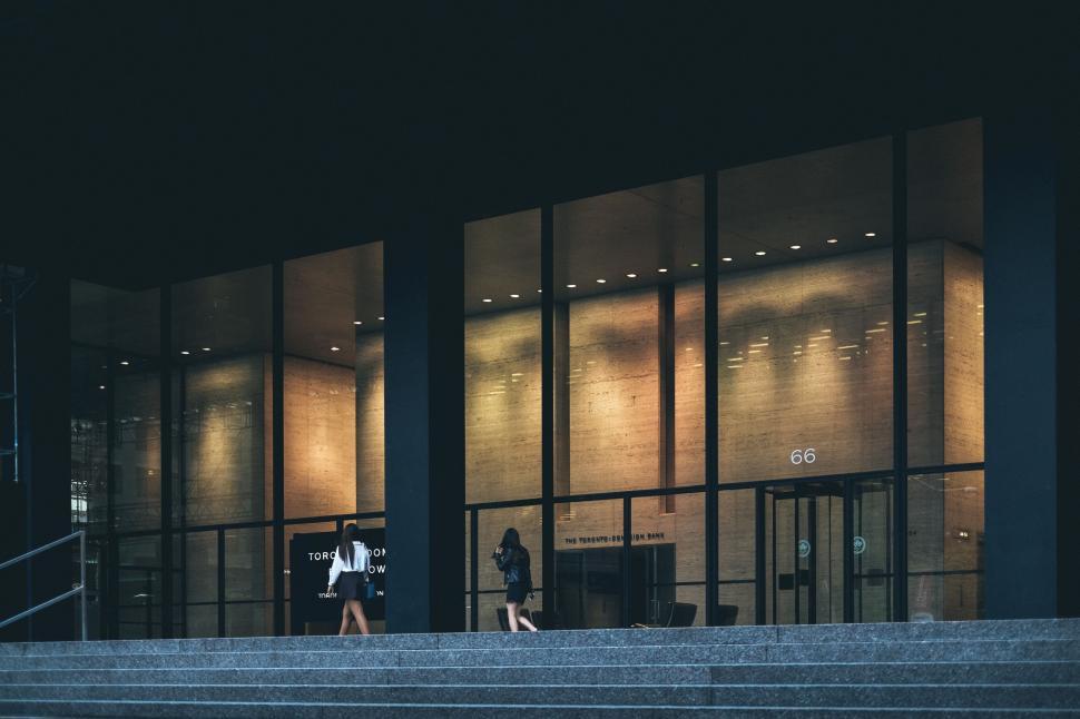 Free Image of Man Walking Down Stairs In Front of Building 