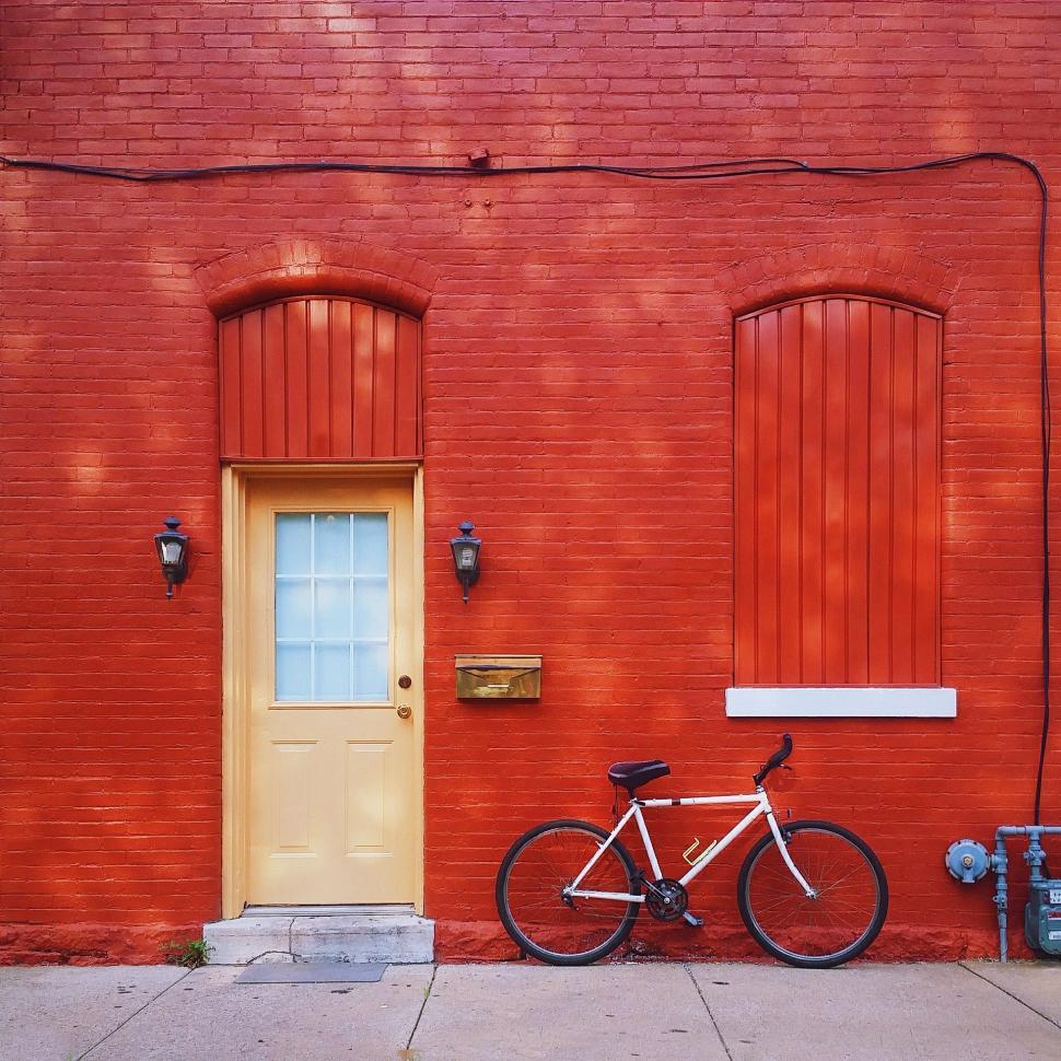 Free Image of Bike Parked in Front of Red Building 