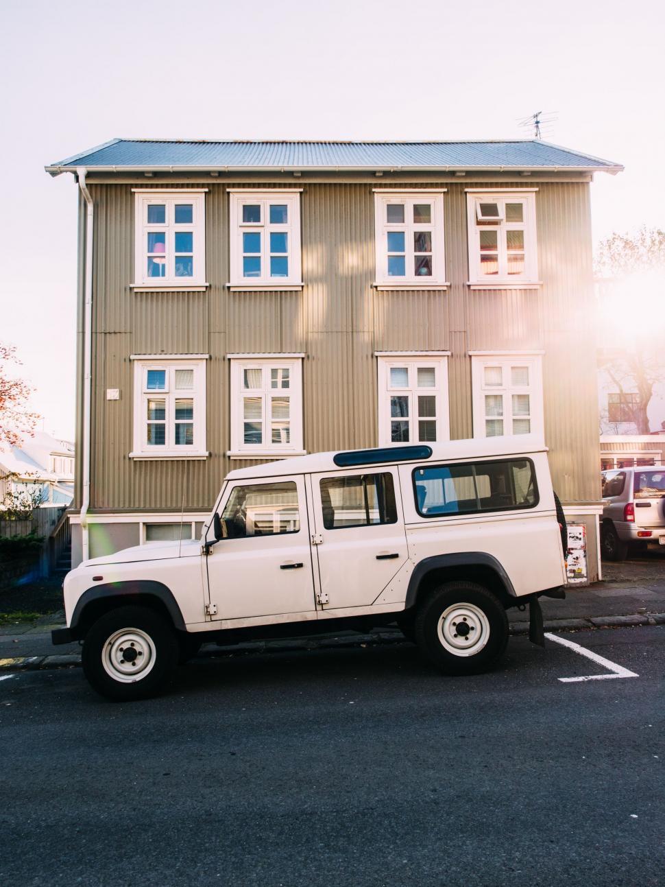 Free Image of White Jeep Parked in Front of Building 